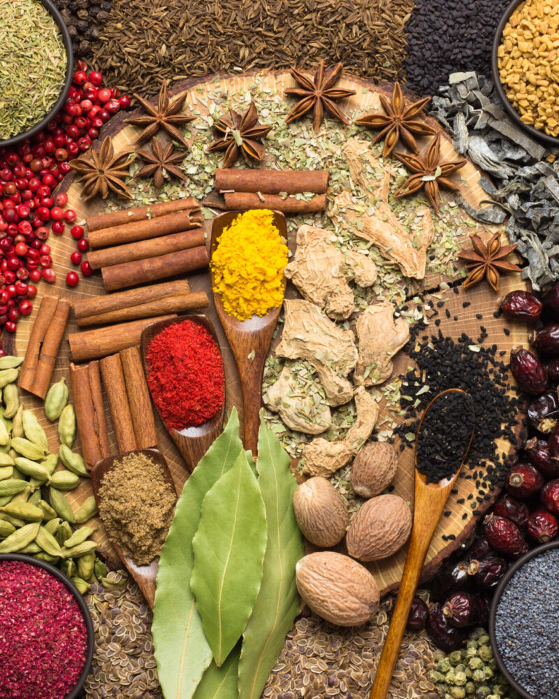 Colorful spices and herbs background. Large set seasonings scattered on table.